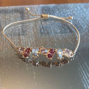 Gold bracelet with pink and silver gems